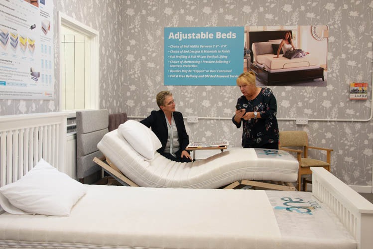 woman showing another woman features of a bed.