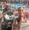 A wheelchair user, on holiday poolside with a lady.
