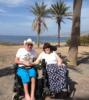 Two wheelchair users by the beach.