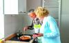 Couple cooking with Unicook Airis Stove Guard Device in situ.